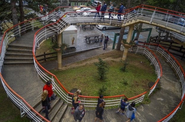 Un grupo de visitantes camina por la pequeña rampa con escalones en forma de caracol que da acceso hasta la salida del teleférico.