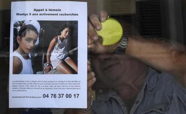 Un hombre coloca un cartel con la foto de la niña desaparecida./Efe