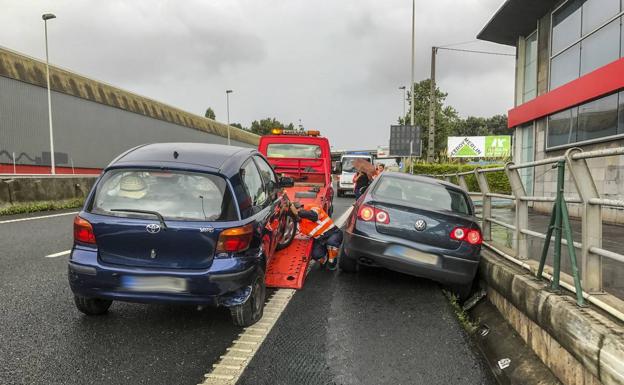 Una grúa retira de la calzada uno de los vehículos siniestrados en el accidente múltiple ocurrido en Maliaño.