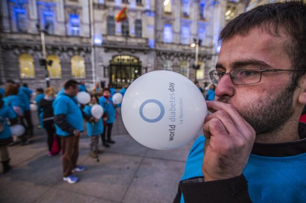 Los ciudadanos formaron el símbolo de la diabetes, un círculo azul, frente al Ayuntamiento, que se iluminó del mismo color./Javier Cotera