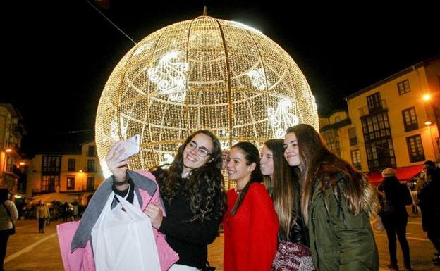 Unas chicas se hacen un selfie ante la bola./Luis Palomeque