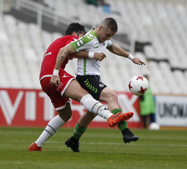 Dani Aquino lucha por el balón con un jugador del Caudal ayer en los Campos de Sport. :: daniel pedriza/