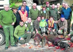 Componentes de la cuadrilla del corraliego Román Varela, con tres jabalíes abatidos en el monte de Caviña. / DM/