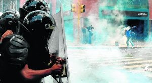 Policías antidisturbios intervienen contra los estudiantes que se manifiestan en las calles de Caracas. / AFP/