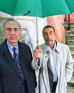 Luis Alberto de Cuenca y Garci pasean ayer entre la lluvia camino de la Filmoteca de Bonifaz. :: ALBERTO AJA/