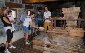 Marco Pérez, guía del Ecoparque Trasmiera, muestra a un grupo de visitantes el funcionamiento del molino de Santa Olaja / Foto: A. Cobo. ::/