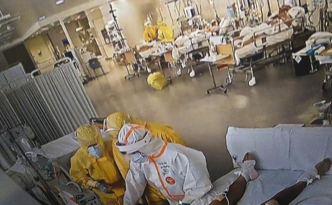 Profesionales sanitarios, cubiertos con todo el equipo de protección que impone el Covid-19, atienden a uno de los pacientes ingresados en la UCI de Valdecilla./DM